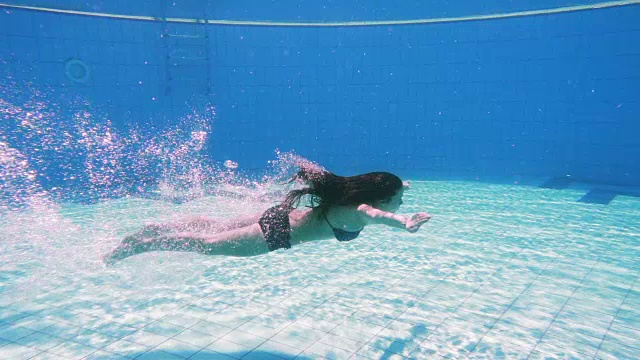 小女孩在游泳池里跳水视频素材