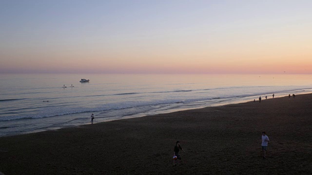 人们在日落时在布莱顿海滩上放松的长镜头。视频素材