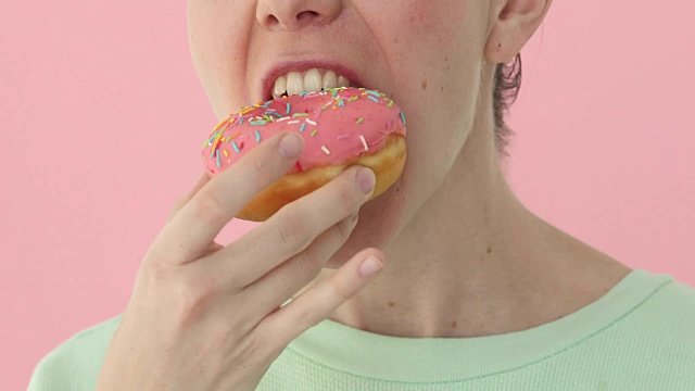 女人在吃甜甜圈特写，美味视频素材