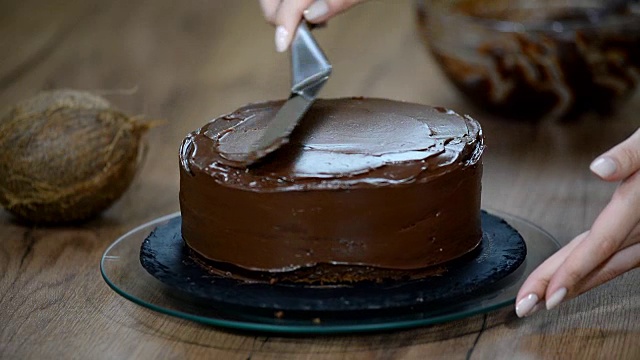糕点师在蛋糕上涂上巧克力奶油。视频素材