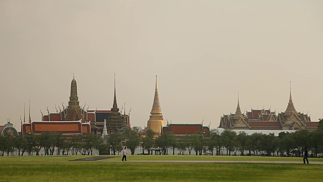 人们穿过田野经过皇宫。泰国曼谷视频素材