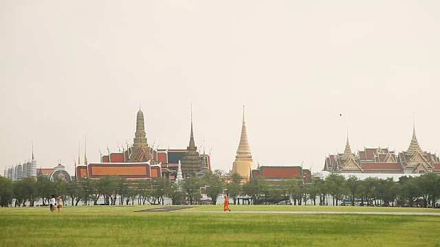 人们穿过田野经过皇宫。泰国曼谷视频素材