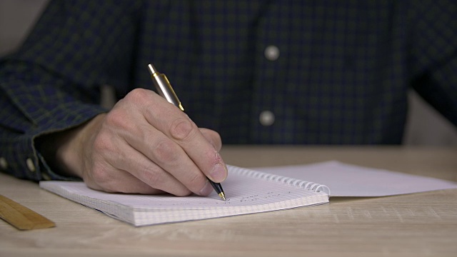 男性的手写在笔记本上。用圆珠笔写日记的人视频素材