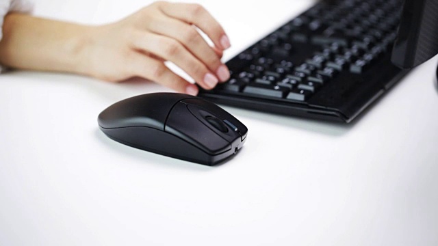 一个女人在办公室用手敲打电脑键盘视频下载