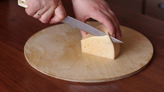 一个女人正在切奶酪，特写镜头。视频素材