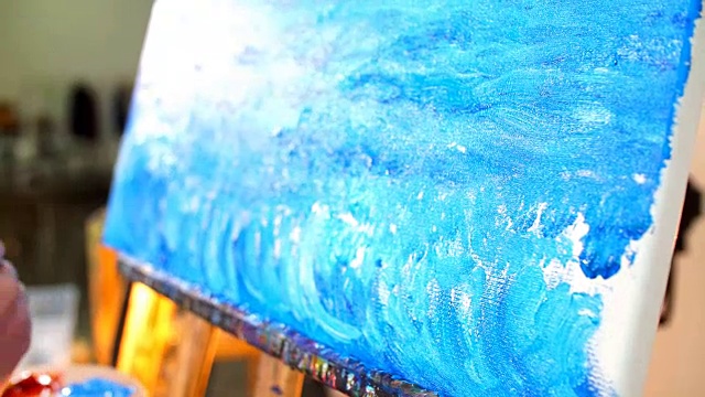 拿着调色板的女子画家正在画海浪的油画视频下载