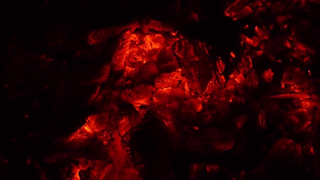 黑暗中燃烧的煤炭的背景。4 k视频素材