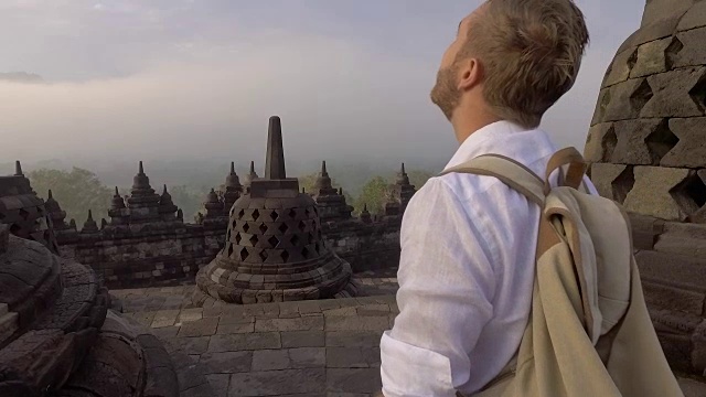 印尼婆罗浮屠寺，一名男子凝视日出的慢动作视频。人们旅行冒险的概念视频素材