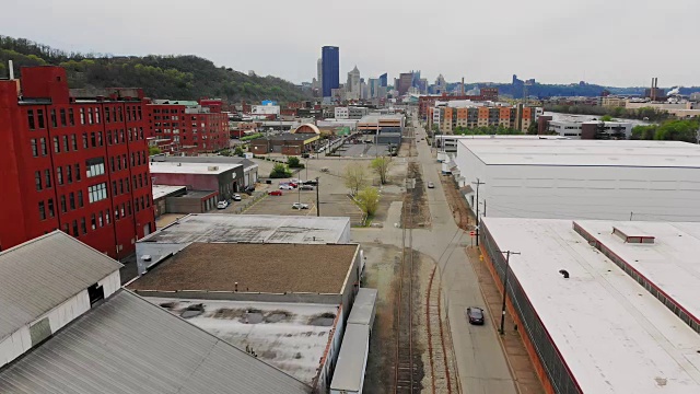 向前鸟瞰工业仓库与匹兹堡天际线在远处视频素材