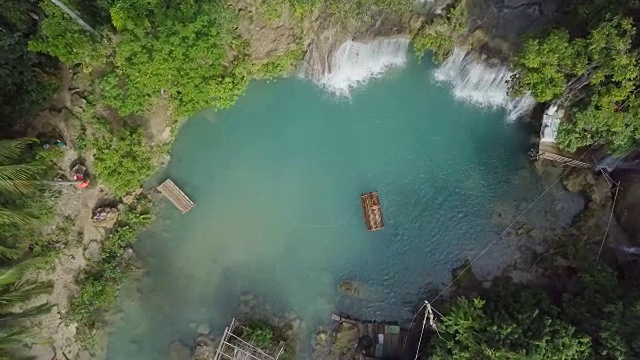无人机从空中拍摄的年轻女子在热带瀑布竹筏。4K分辨率的视频，在菲律宾拍摄。人们旅行乐趣度假冒险概念视频素材
