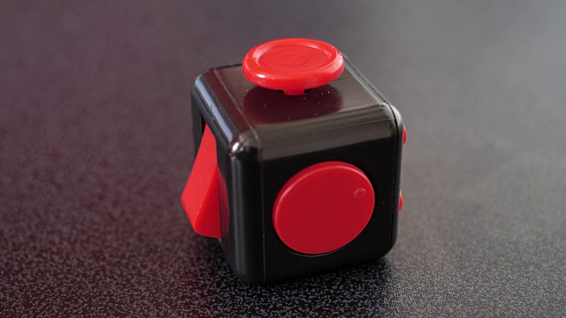 红色和黑色坐立不安的立方体在黑色的桌面上，焦点拉视频下载