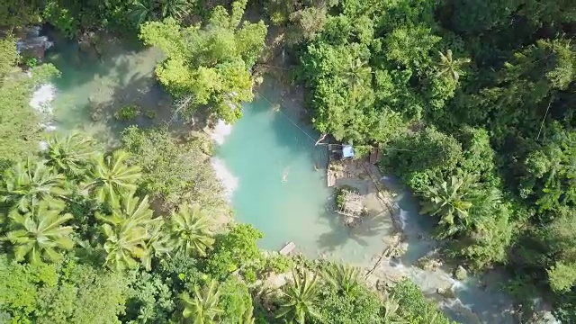 无人机航拍的年轻女子在热带瀑布游泳。4K分辨率的视频，在菲律宾拍摄。人们旅行乐趣度假冒险概念视频素材