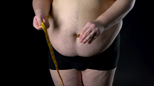超重男子用卷尺量肚子，体重减轻，营养不良视频下载