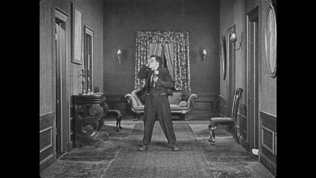 1921年，困惑的男人(巴斯特·基顿)试图帮助穿着服装的男人举起女人，但当两个骷髅出现时逃跑了视频下载