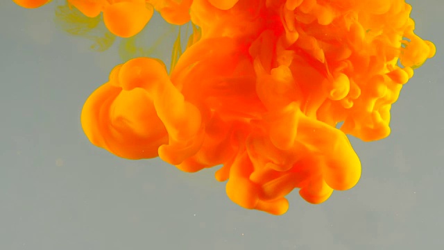 墨水在水里。橙色的颜料与水发生反应，形成抽象的云状结构。可以用作过渡，添加到现代垃圾项目，艺术背景，任何创造性扭曲视频素材