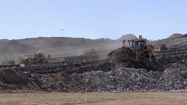 推土机正在移动煤矿里堆积如山的土堆视频素材