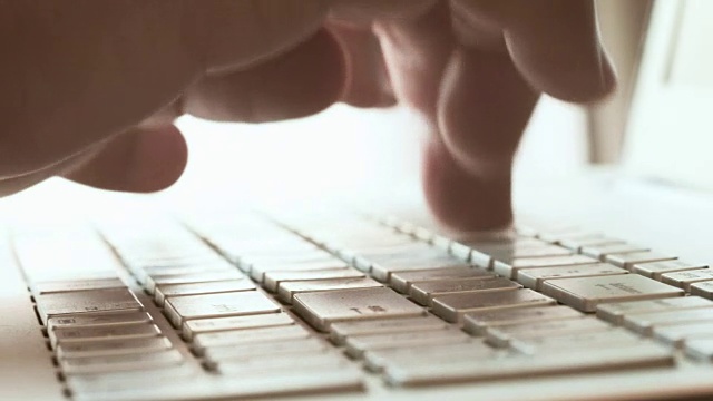 一个手在电脑键盘上打字的特写镜头，包括环境音视频素材