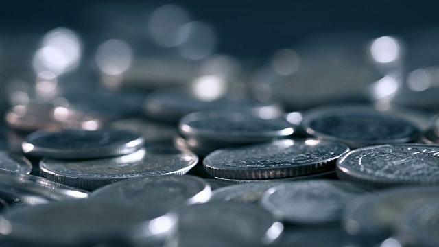 黑光下的硬币在地板上堆积的特写，商业和金融省钱或投资背景的概念，非常近，浅景深视频下载