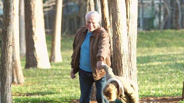 男孩拉着爷爷，在公园里散步视频下载