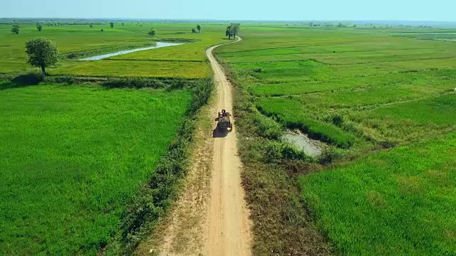无人机拍摄:一名农民驾驶着两轮拖拉机在稻田里低空飞行视频素材