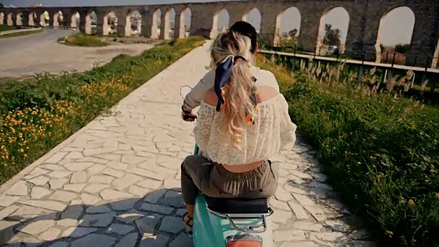在欧洲度假的年轻游客夫妇骑着复古滑板车视频素材