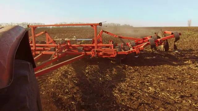 农民在拖拉机犁地俄罗斯稳定摄像机运动农业土壤准备土地与苗床中耕作为提前播种生活方式活动的一部分，在早春季节的农业工作在农田。农业的概念视频素材
