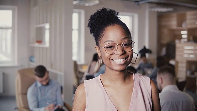 美丽的年轻非洲裔美国成功女商人的肖像，看着在阁楼办公室背景4K相机视频素材