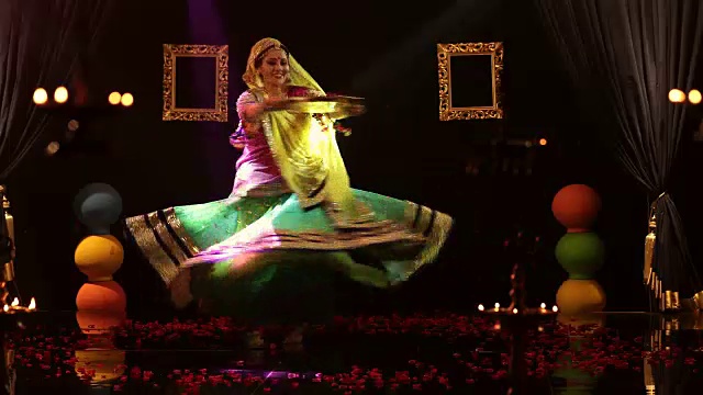 女士手持一盘玫瑰花瓣，在舞台上表演传统古玛舞/印度视频下载