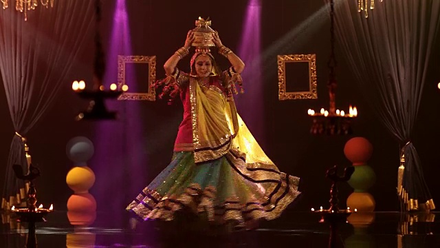 在印度舞台上表演传统古玛舞时，一名女子头顶着燃烧的锅视频下载