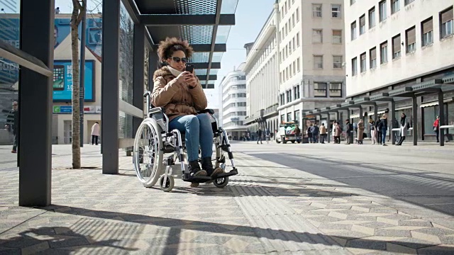 残疾的小女孩坐在轮椅上，在市中心视频素材