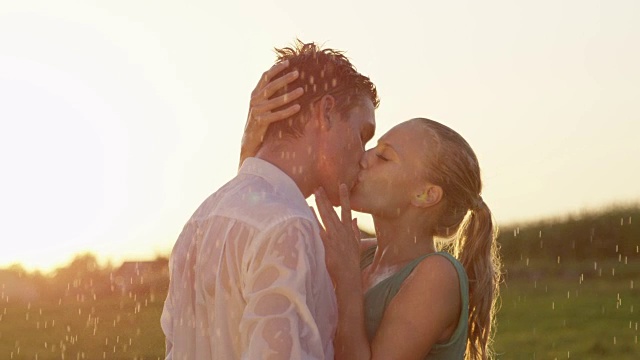 镜头光晕:一个金发女人在雨中亲吻男友的脸。视频下载