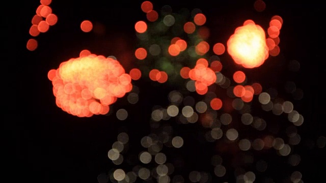 红色、白色和绿色的烟花在假日晚上的散景天空背景中模糊视频下载
