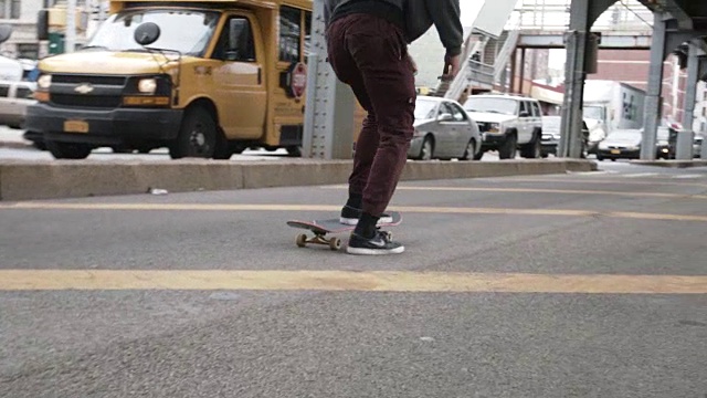 一个年轻的混合种族男子滑板的特写镜头。视频素材