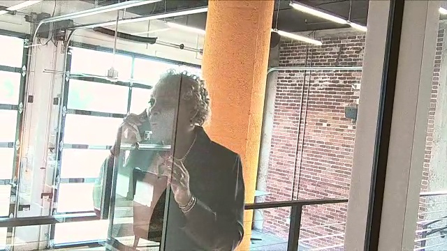 非裔美国妇女在市里的大楼里打电话视频素材