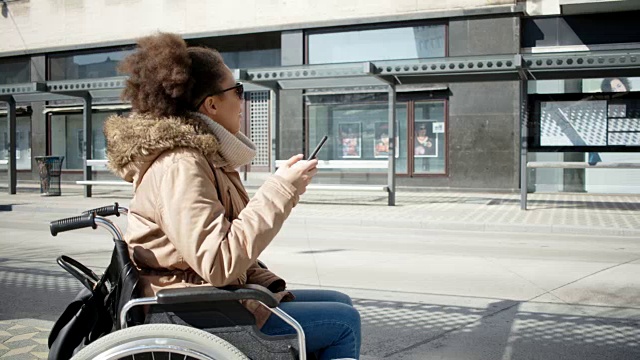 残疾的小女孩坐在轮椅上，在市中心视频素材
