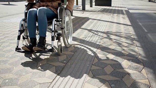 在市中心的公共汽车站上坐着轮椅的残疾小女孩视频素材