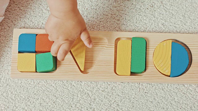 孩子玩的木制玩具婴儿分类与几何图形。俯视图视频素材