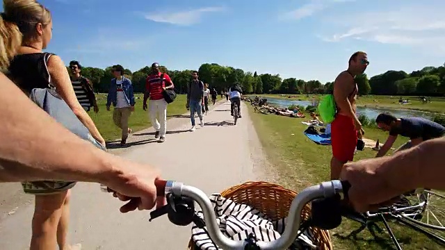人们在湖边的路上骑自行车视频素材