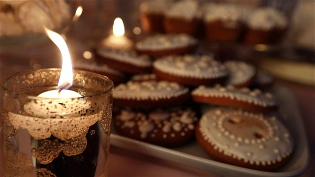 糖果在餐厅，孩子们的聚会，生日，点燃的蜡烛，燃烧的蜡烛在烛台上的桌子视频下载