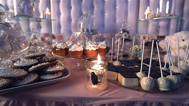 糖果条在餐厅，儿童聚会，生日，点燃的蜡烛，燃烧的蜡烛在一个烛台上的桌子，糖果条在背景，糖果条设计的餐厅，设计糖果条视频下载