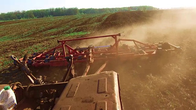 农民在拖拉机steadicam运动俄罗斯农业土壤地面准备土地与苗床耕作作为预播种活动的一部分，在早春季节的生活方式农业工作在农田。农业的概念视频素材