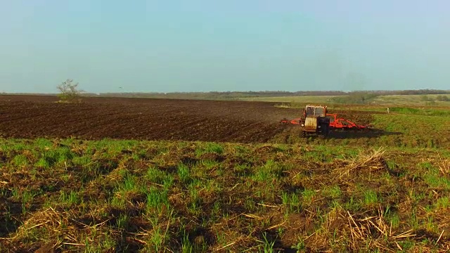 农民在拖拉机土壤犁稳定的运动农业地面俄罗斯准备土地与苗床中耕作为农业工作的预播活动的一部分在早春季节在农田。农业概念的生活方式视频素材
