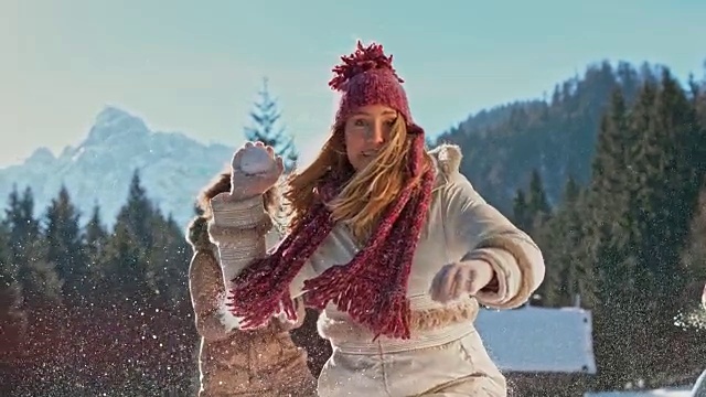 一名年轻女子把雪球扔进照相机视频素材