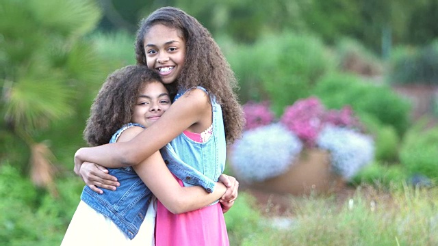 两个非裔美国姐妹在花园里微笑视频素材