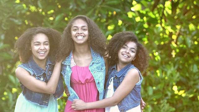 三个非裔美国姐妹在花园里大笑视频素材