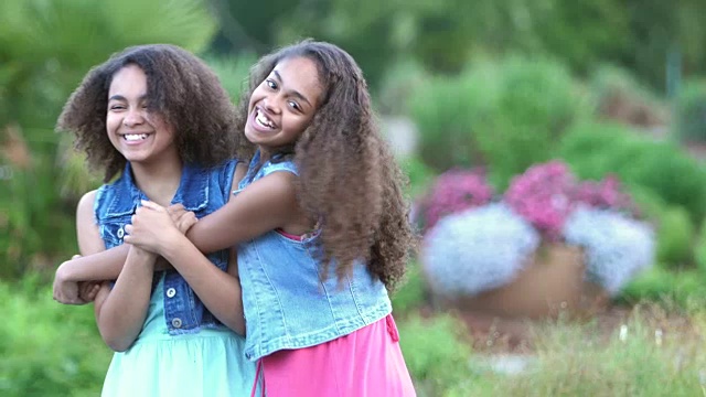 两个非裔美国姐妹在花园里微笑视频素材