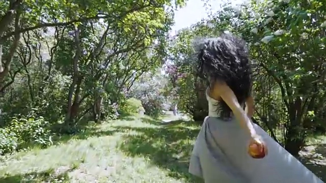 手里拿着苹果的美丽女人跑过花园，白雪公主的童话视频下载