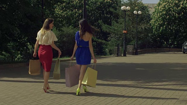 快乐的购物女性走在城市的街道上视频素材