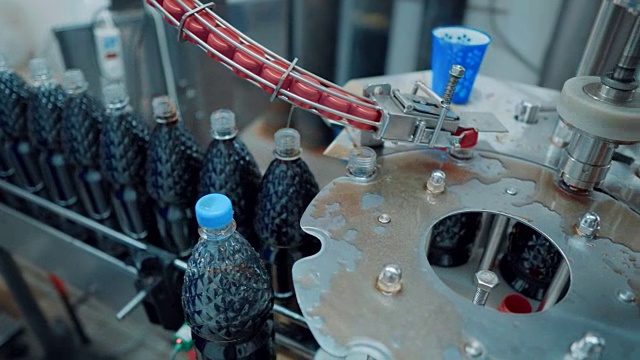 碳酸饮料生产线。瓶装水和苏打水在工厂里由传送带运输视频素材