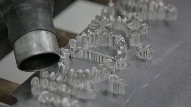 牙科技师在3D中吹掉种植体上的粉末视频下载